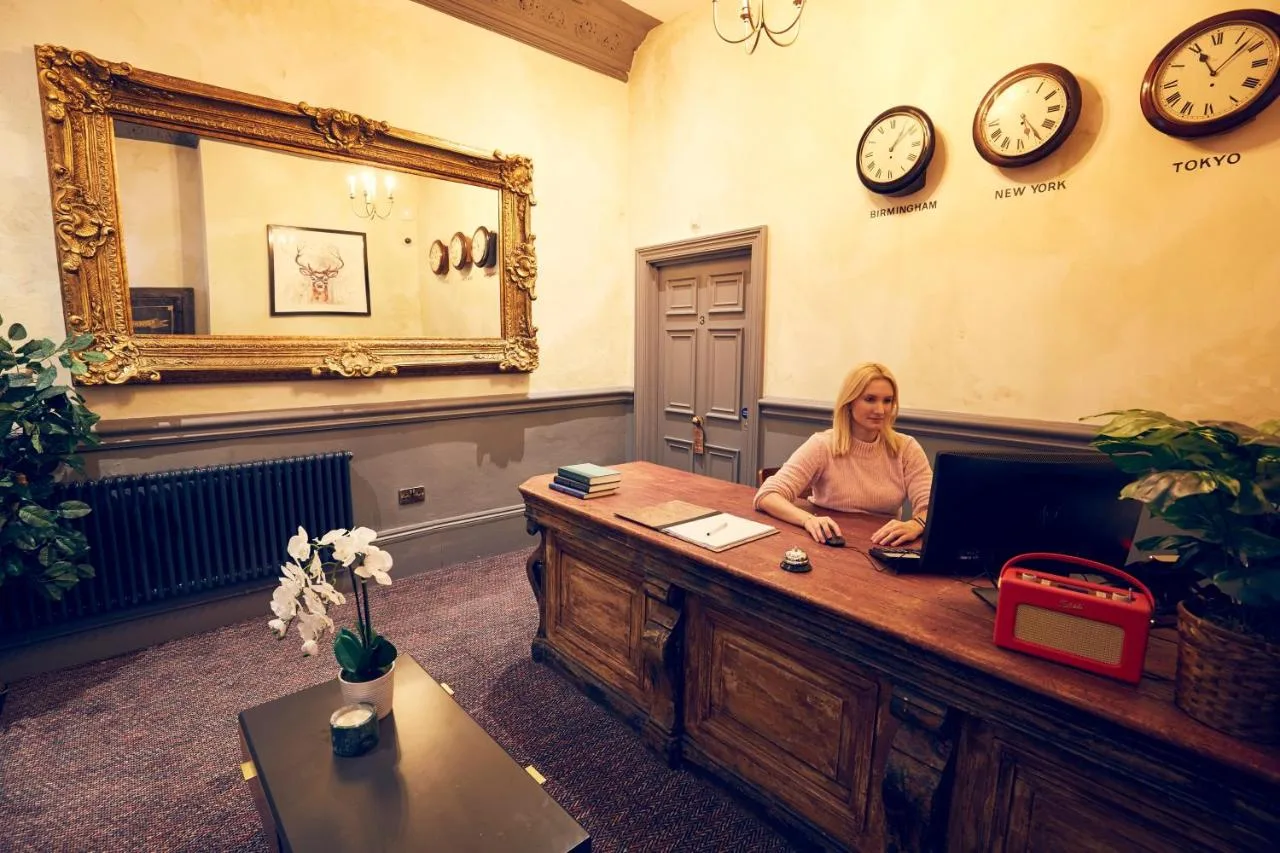 A woman sitting at a desk with a laptop at Frederick Street Townhouse in Birmingham