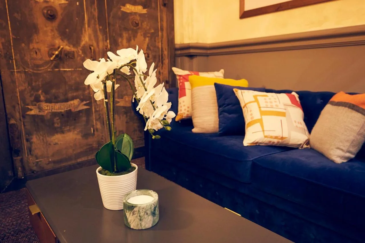 A blue couch with pillows and a table with a plant at Frederick Street Townhouse in Birmingham
